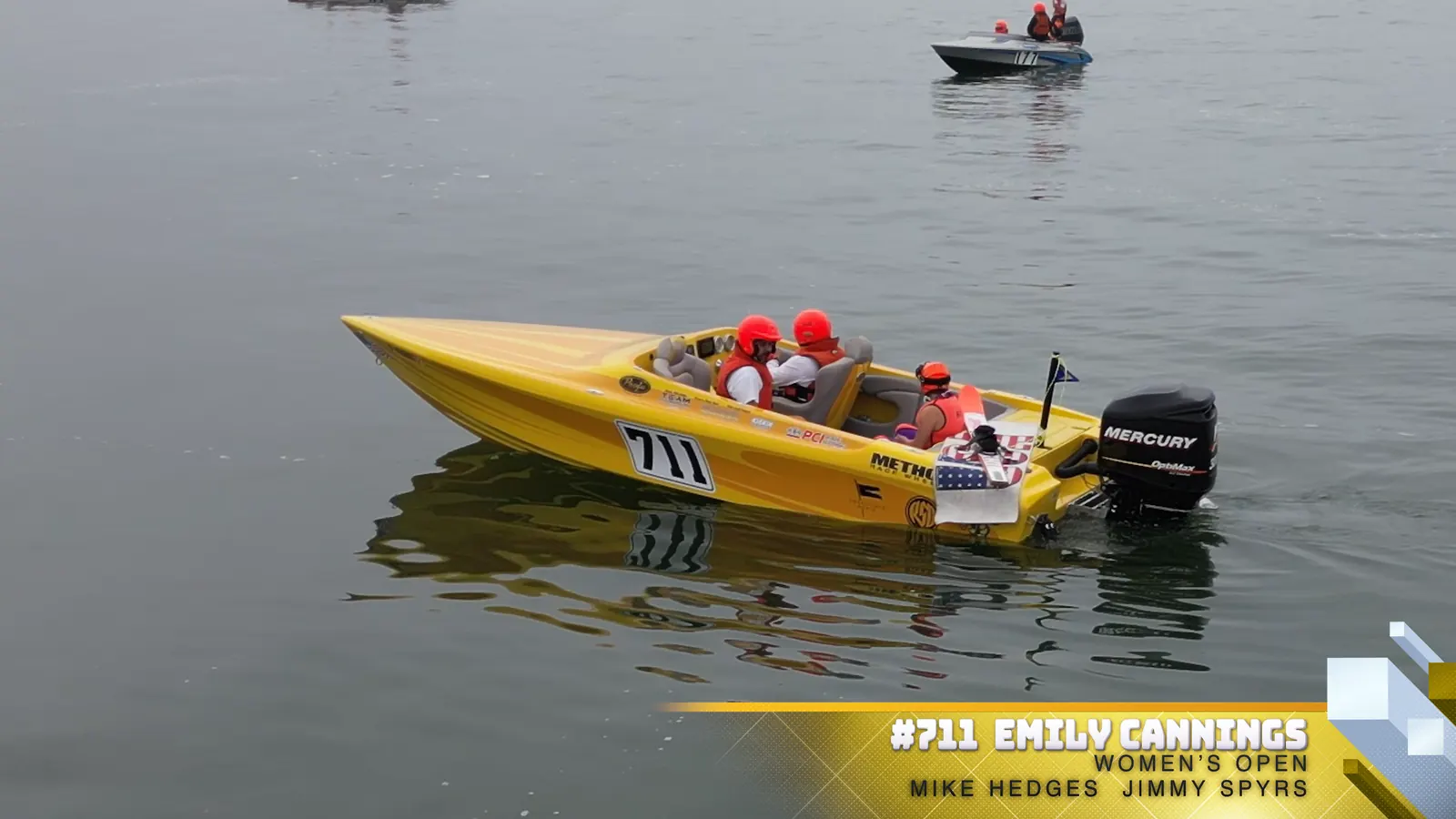 Number 711 race boat and crew on calm water