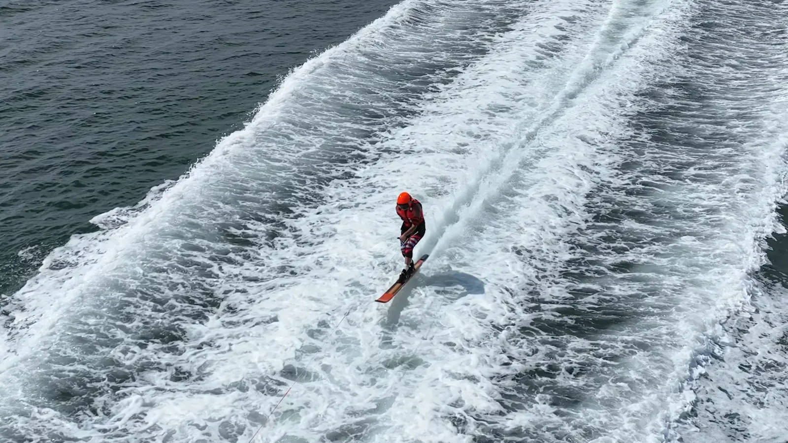 Water skier centered between two sweeping wakes